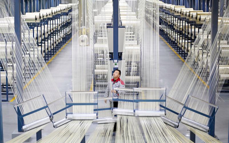 在中国建材集团西宁万吨碳纤维生产基地,工作人员整理碳纤维原丝.
